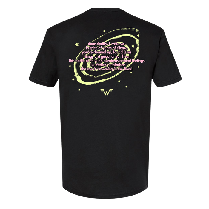 Black short-sleeved t-shirt featuring a glowing yellow circular design with stars and pink text, centered around the wonder woman logo.