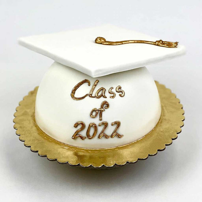 White Grad Cap Cake featuring a golden tassel, gold base, and a โClass of 2022โ message in gold