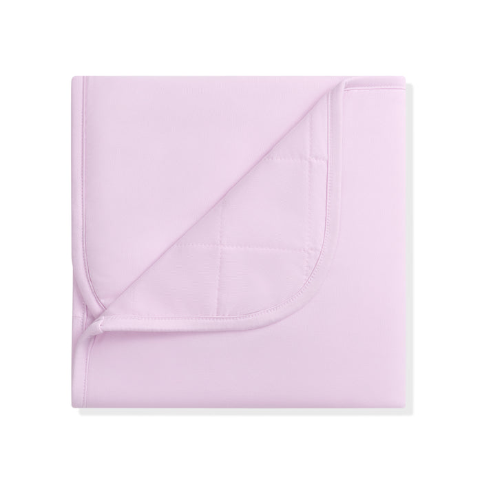 Folded light purple bamboo blanket on a white background