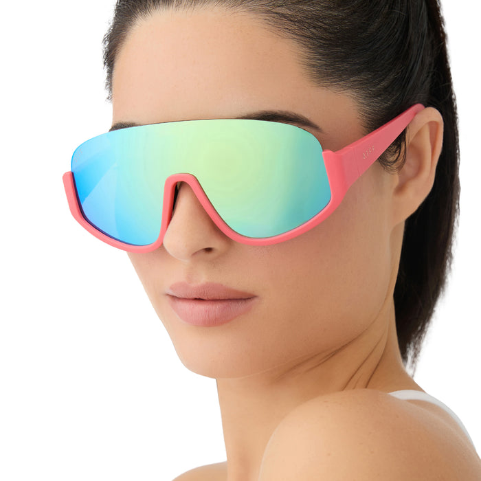 on model - female wearing diff sport featuring the blazer shield sunglasses with a coral frame and turquoise ice mirror polarized lenses angled view