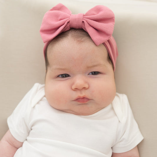 Baby wearing Bow Headband in Apple Blossom with white bodysuit