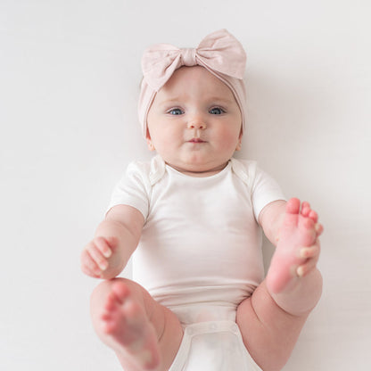 Baby wearing Bow Headband in Blush and Cloud Bodysuit