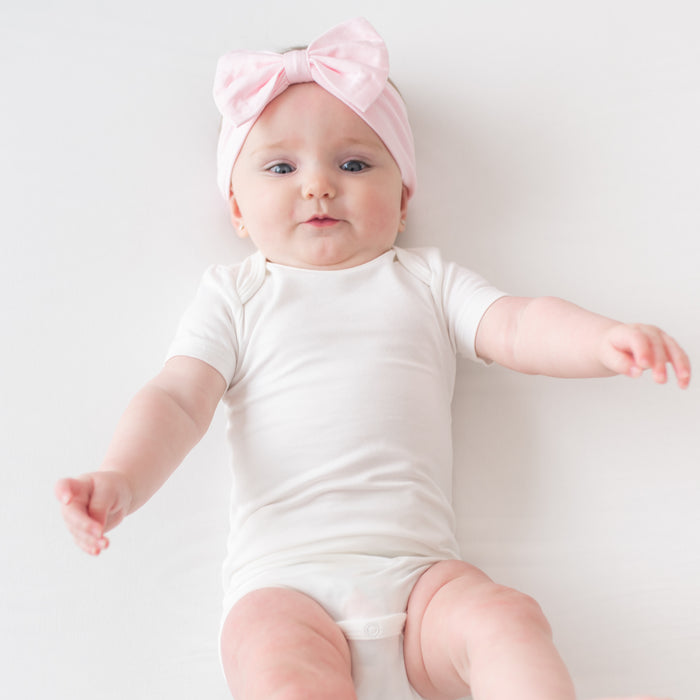 Infant wearing white bodysuit and pink Bow Headband in Sakura