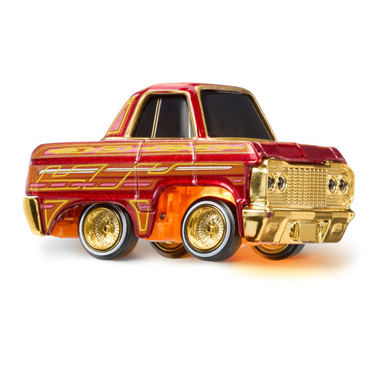 Red and gold toy truck with orang light underneath on a white background