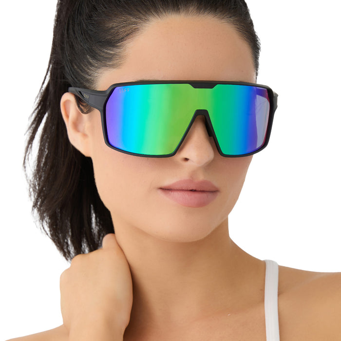 on model - female wearing diff sport featuring the charge shield sunglasses with a matte black frame and green mirror polarized lenses front view