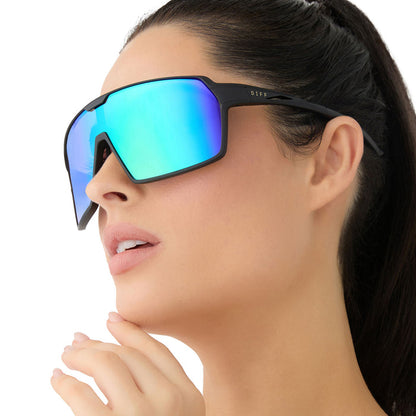 on model - female wearing diff sport featuring the charge shield sunglasses with a matte black frame and green mirror polarized lenses angled view