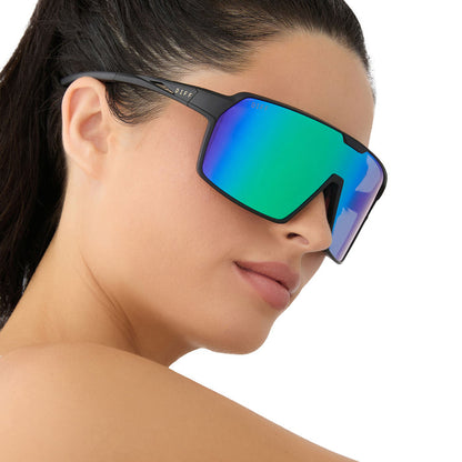 on model - female wearing diff sport featuring the charge shield sunglasses with a matte black frame and green mirror polarized lenses side view