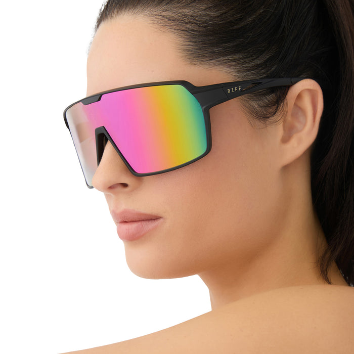 on model - female wearing diff sport featuring the charge shield sunglasses with a matte black frame and pink rush mirror polarized lenses angled view