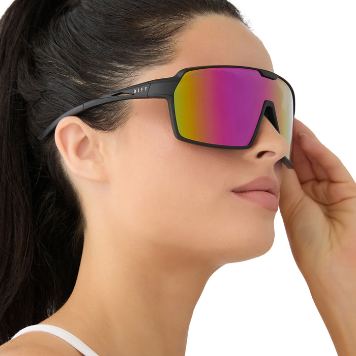 on model - female wearing diff sport featuring the charge shield sunglasses with a matte black frame and pink rush mirror polarized lenses side view