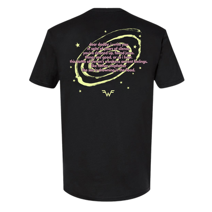 Black short-sleeved t-shirt featuring a glowing yellow circular design with stars and pink text, centered around the wonder woman logo.