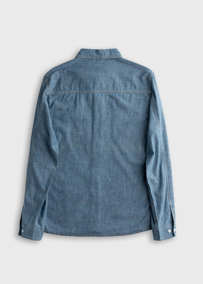 Back view of a blue denim shirt with long sleeves and buttoned cuffs, displayed on a plain gray background.