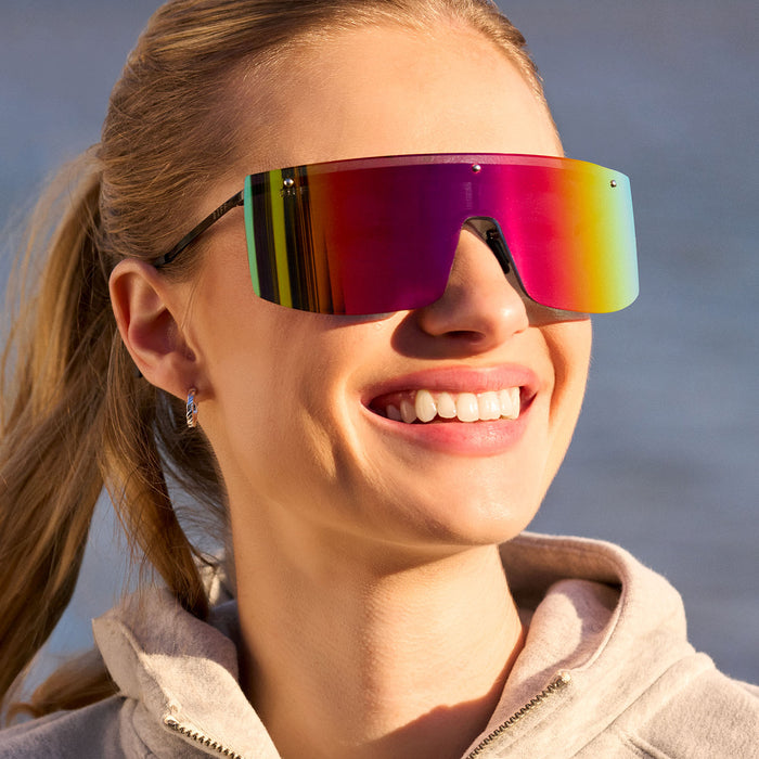 on model - female wearing diff sport featuring the grandslam shield sunglasses with a black frame and rainbow mirror polarized lenses front view