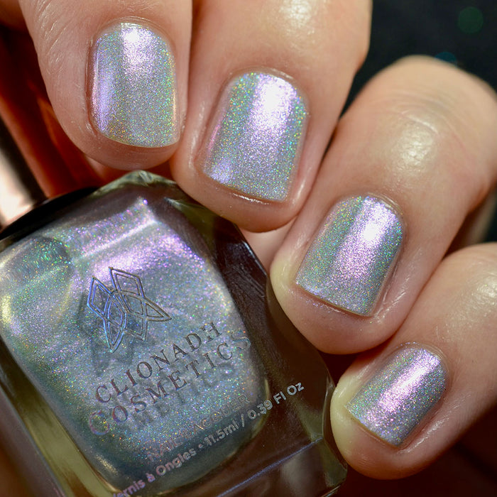 Close-up of nails painted with Boneyard Nail Lacquer on fair skin tone. Hand is holding polish bottle.