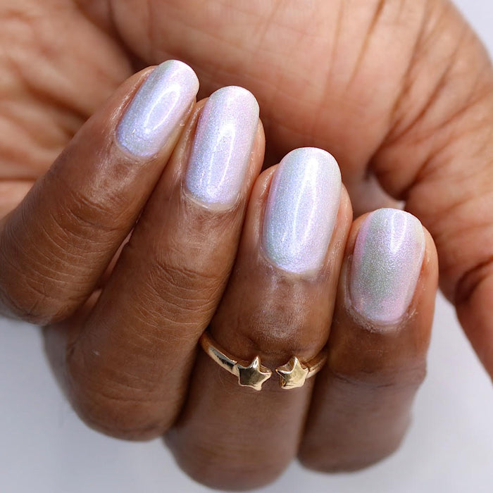 Upside down, close-up of nails painted with Boneyard Nail Lacquer on deep skin tone.