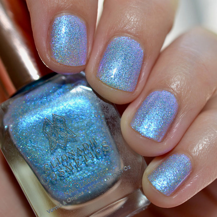 Close-up of nails painted with Mausoleum Nail Lacquer on fair skin tone. Hand is holding polish bottle.