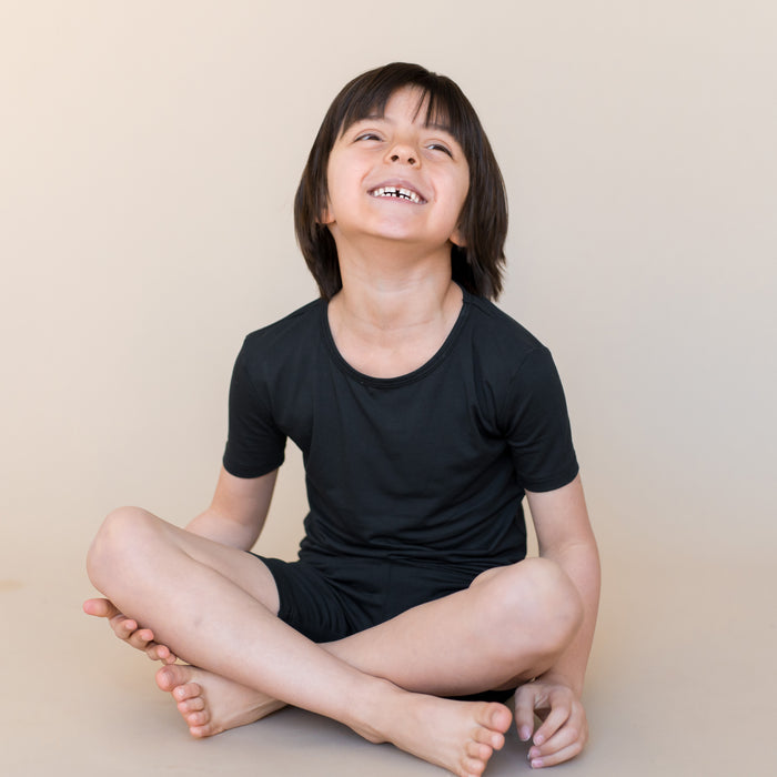 Young boy wearing short sleeve black pajama set