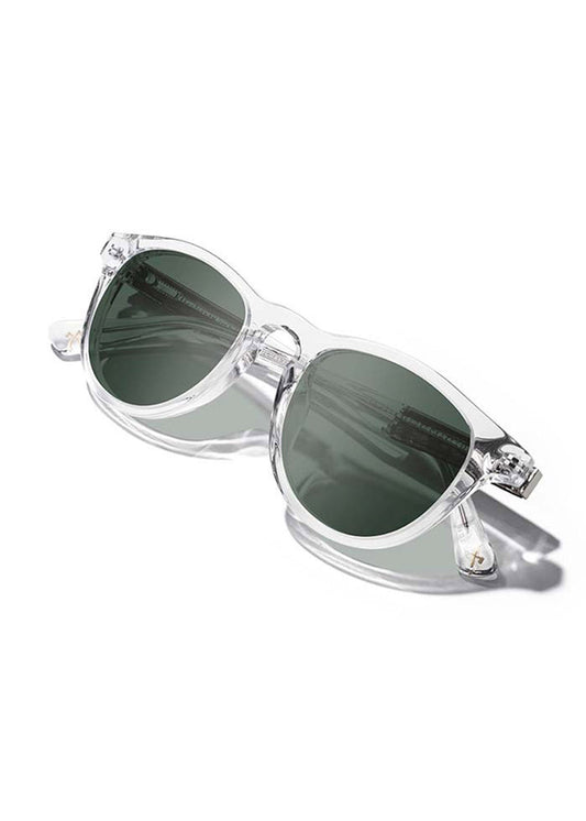 Clear-framed sunglasses with dark lenses on a white background, casting a soft shadow.