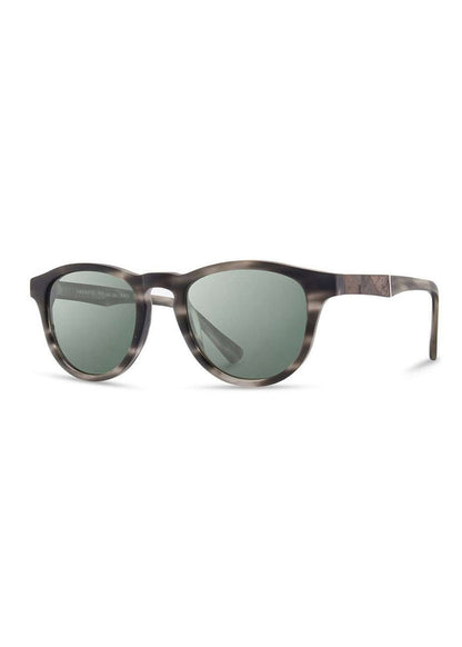 Stylish sunglasses with round, dark lenses and a sleek, tortoiseshell frame, angled slightly to the left against a white background.