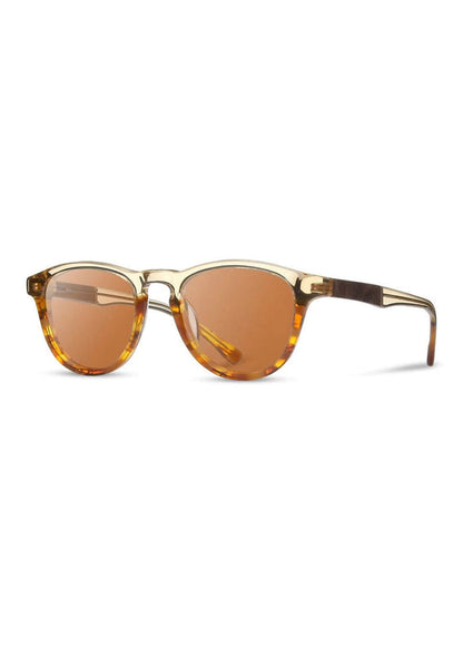 Stylish sunglasses with round amber lenses and tortoiseshell frames, set against a white background, showcasing modern design.