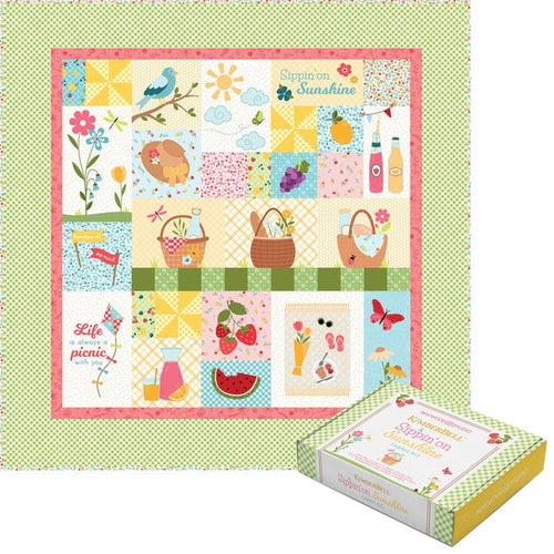 Colorful quilt with patchwork design featuring nature and picnic elements, displayed on a green polka dot background.
