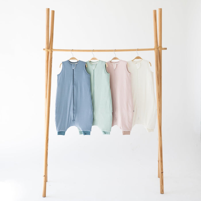 Kyte Baby sleep bag walkers 1.0 in Slate, Sage, Blush and Cloud hanging on a wooden rack