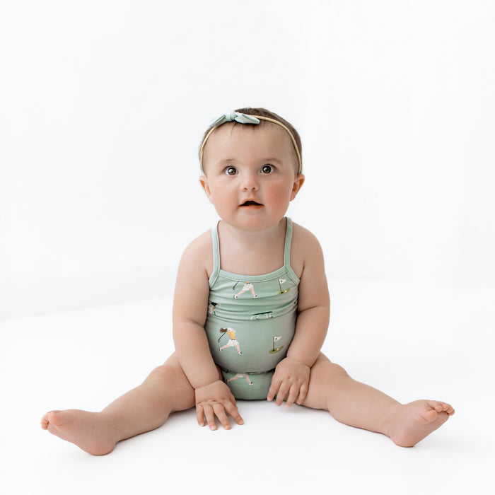 Baby wearing Spaghetti Strap Leotard in Golf and sage bow