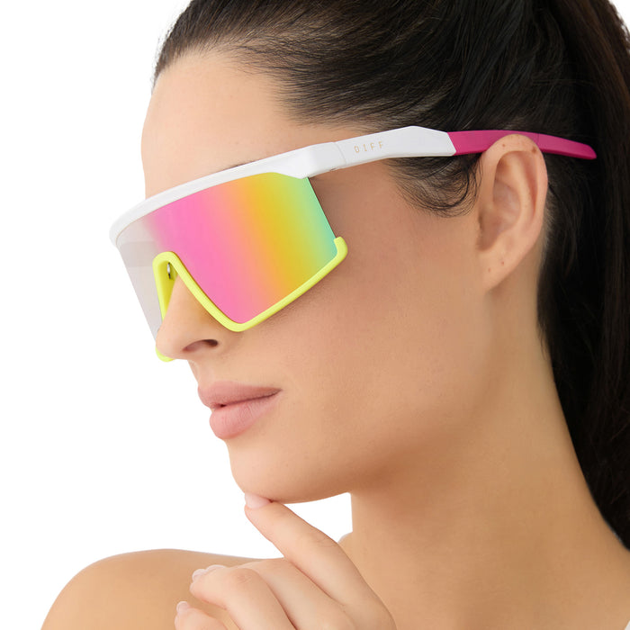 on model - female wearing diff sport featuring the spike shield sunglasses with a matte white + neon yellow + hot pink frame and pink rush mirror polarized lenses angled view