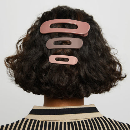 Model wearing Terracotta Flat Claw Clips in short curly hair against a light gray background