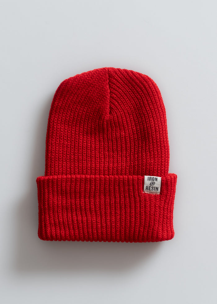Red knit beanie with a folded brim and a small "Iron and Resin" label, set against a plain white background.