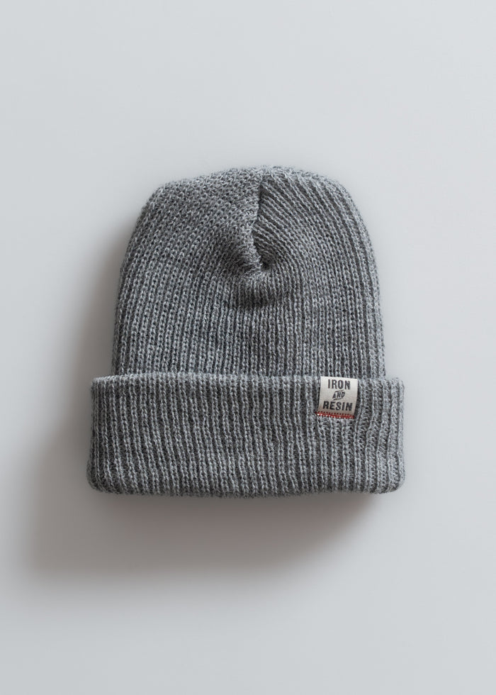 Gray ribbed beanie with "Iron and Resin" label on cuff, displayed on a light background, showcasing casual winter style.