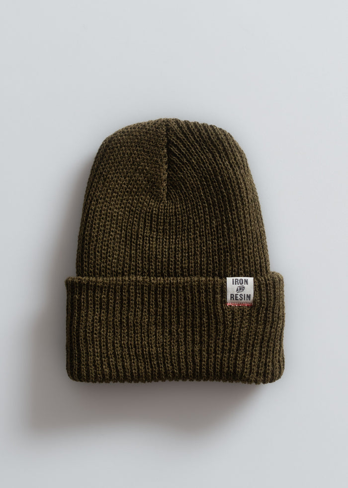 A brown knit beanie with a folded brim and an "Iron and Resin" label, displayed against a plain white background.