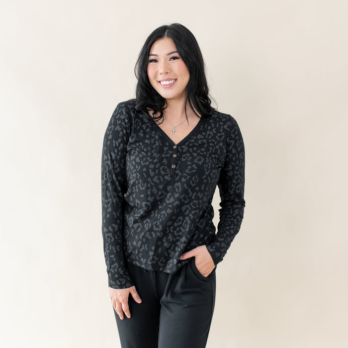 Woman wearing Kyte Baby Women's Long Sleeve Henley Tee in Midnight Leopard