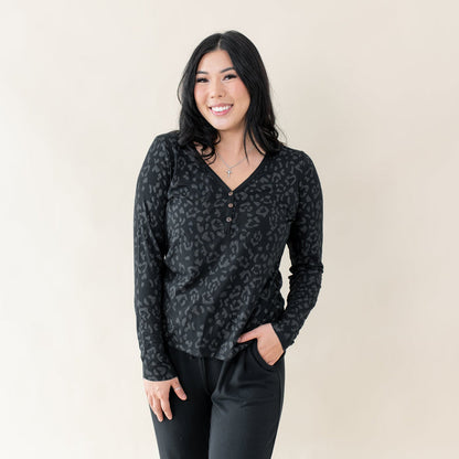 Woman wearing Kyte Baby Women's Long Sleeve Henley Tee in Midnight Leopard