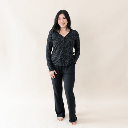Woman wearing Kyte Baby Women's Breathable Long Sleeve Henley Tee in Midnight Leopard