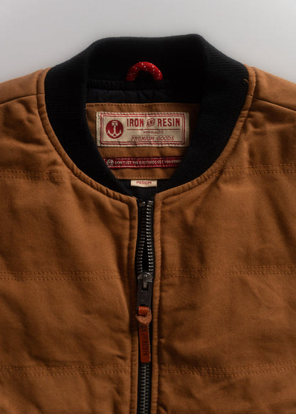 Brown jacket with black collar, featuring Iron and Resin label. Visible zipper and red hanging loop. Size medium.